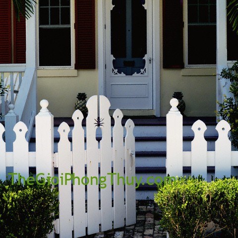 White picket fence in front of porch with red shutters on windows --- Image by © Dana Hoff/Beateworks/Corbis